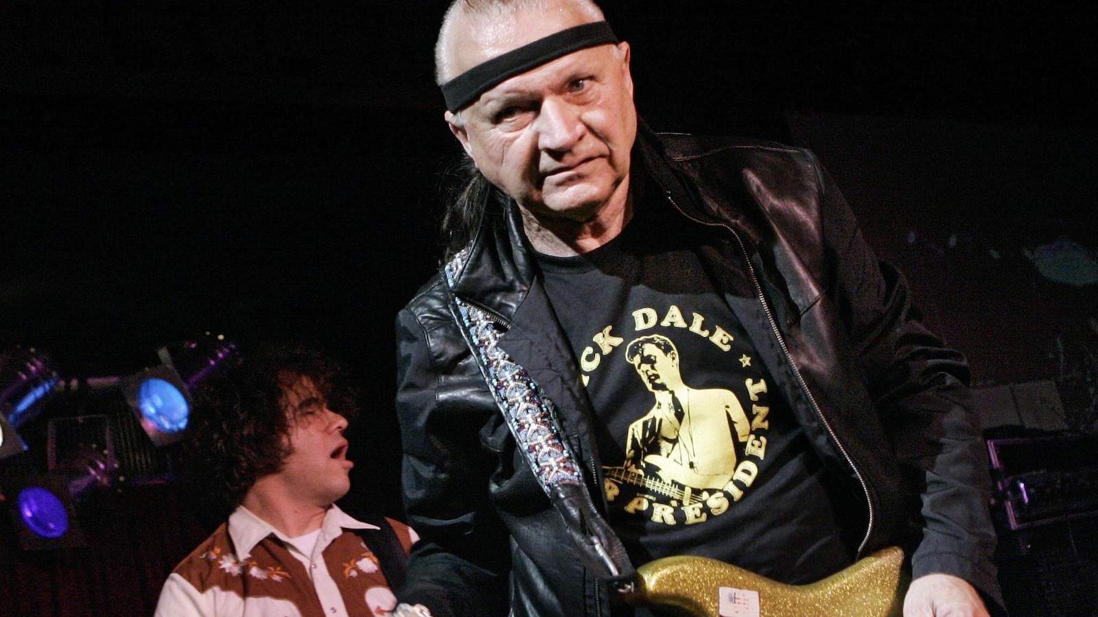 Dick Dale tient une guitare à la main.