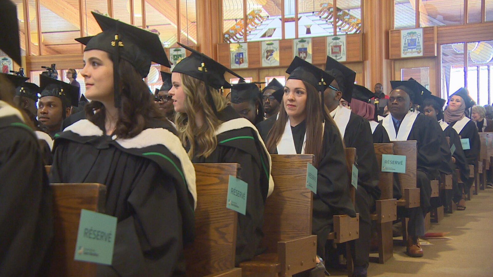 Des étudiants en toge assis lors d'une cérémonie de remise des diplômes.