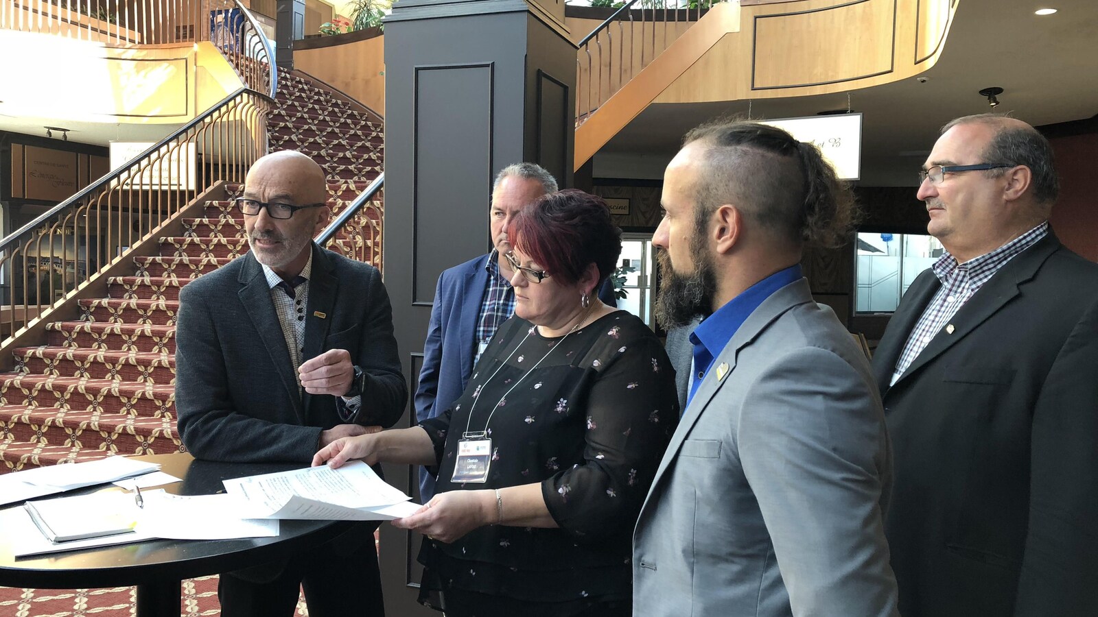 Des élus régionaux prennent place autour d'une place et écoutent le maire de Rimouski prendre la parole.