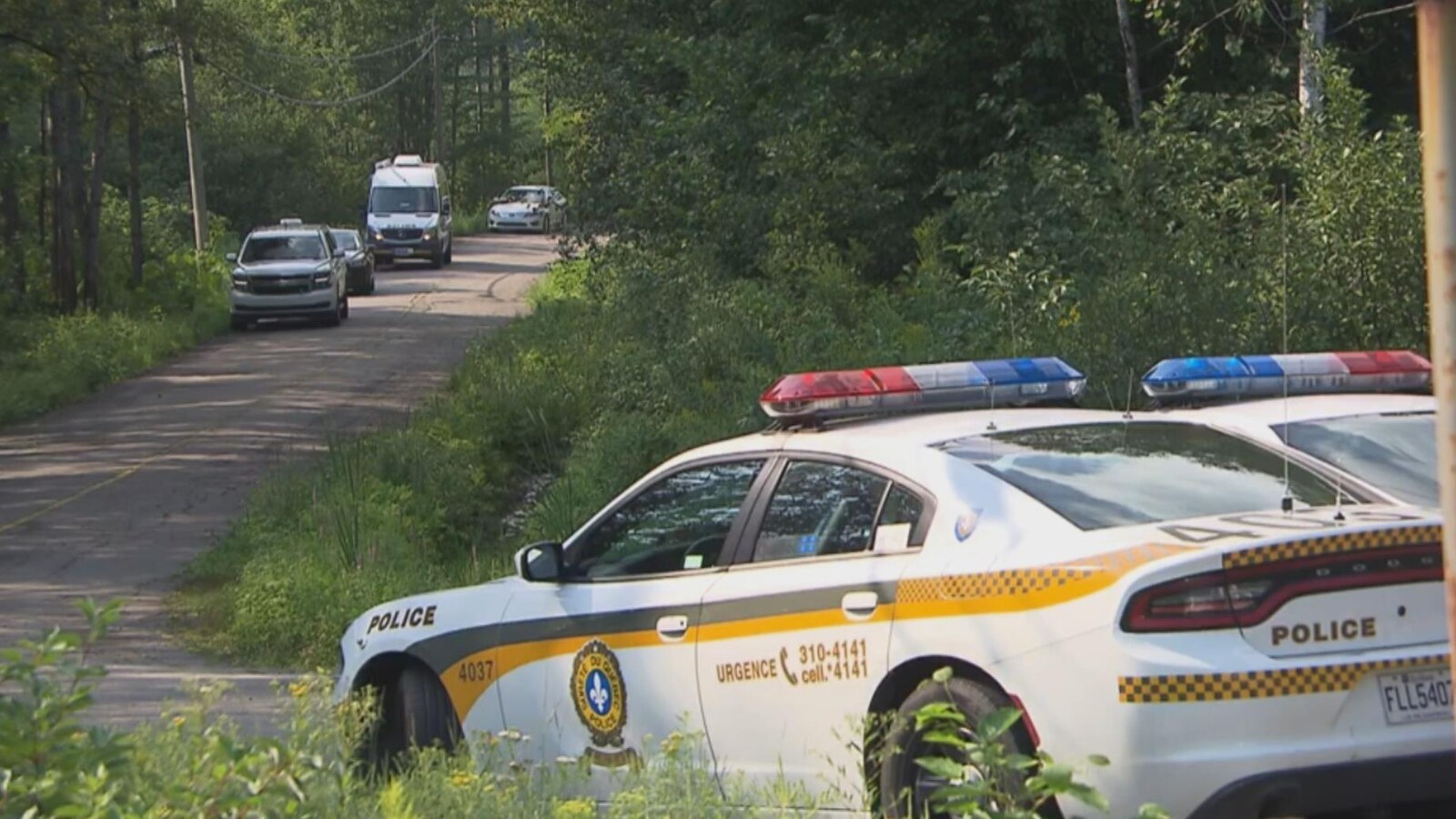 Des autopatrouilles de la Sûreté du Québec stationnés sur une route de campagne.