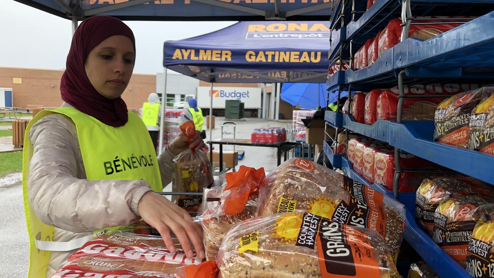 Une bénévole place des pains sur une étagère.