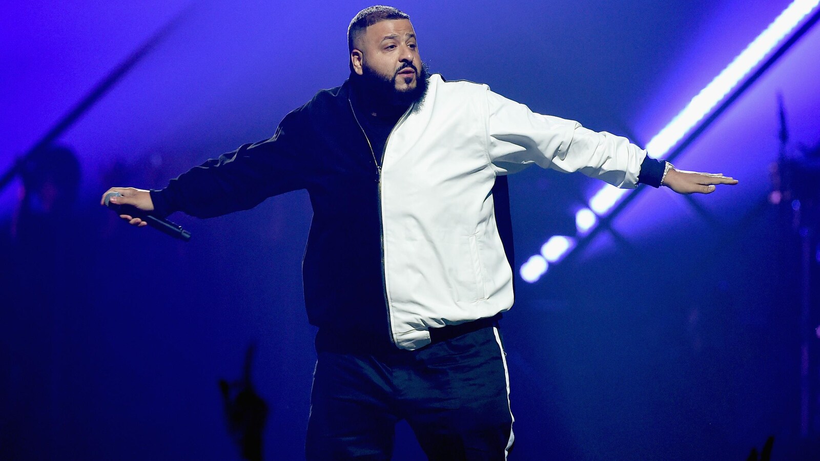 DJ Khaled est sur scène et écarte les bras.