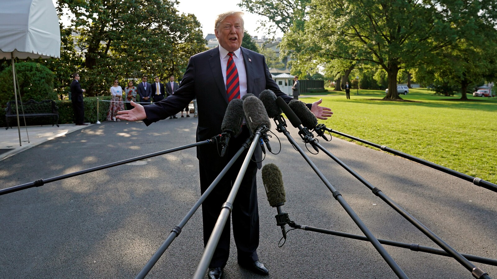 Trump parle devant de nombreux micros tendu par des perches.