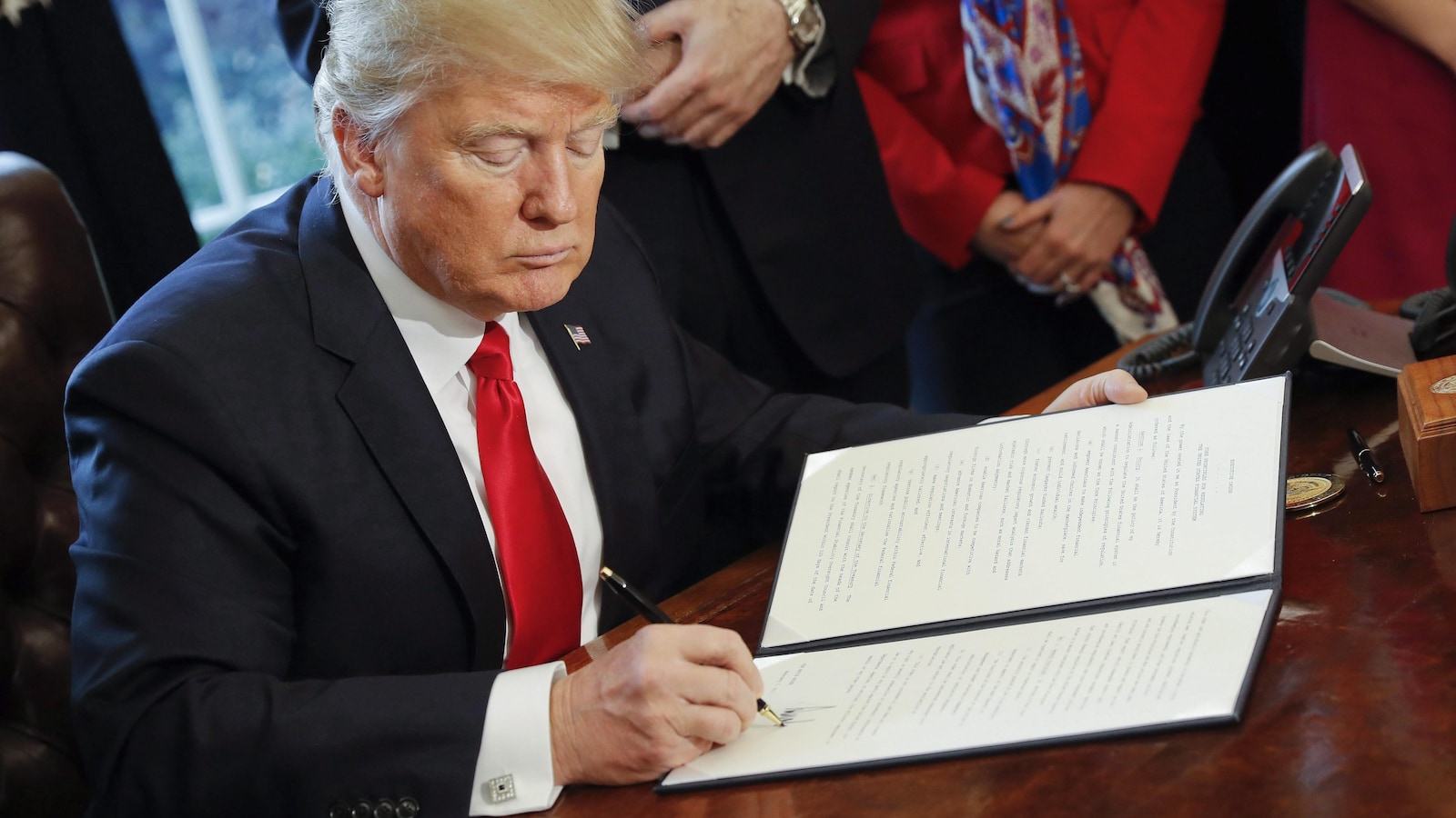 Le président américain, Donald Trump, appose sa signature au bas d'un décret présidentiel à la Maison-Blanche.