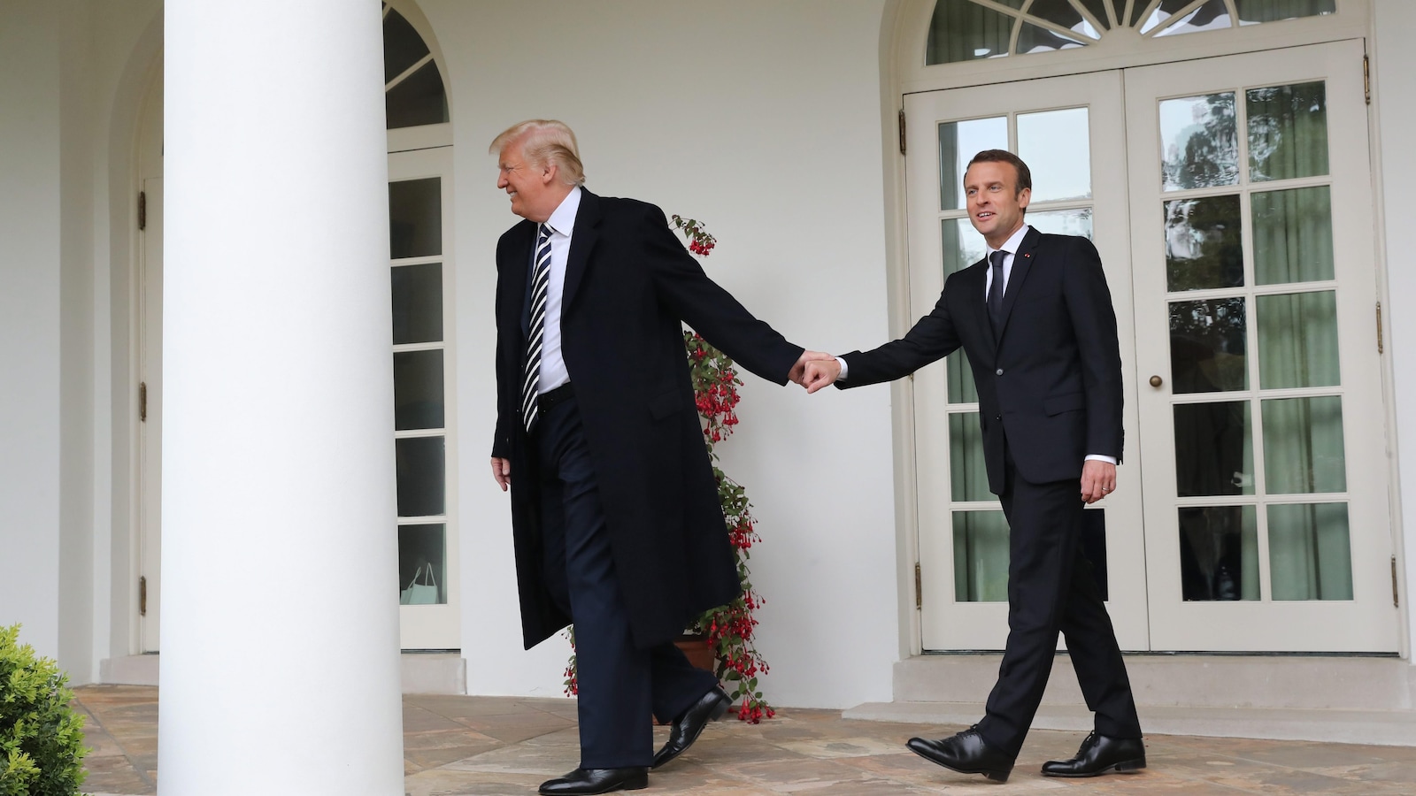 Donald Trump tient Emmanuel Macron par la main pour l'entraîner à l'intérieur de la Maison-Blanche.