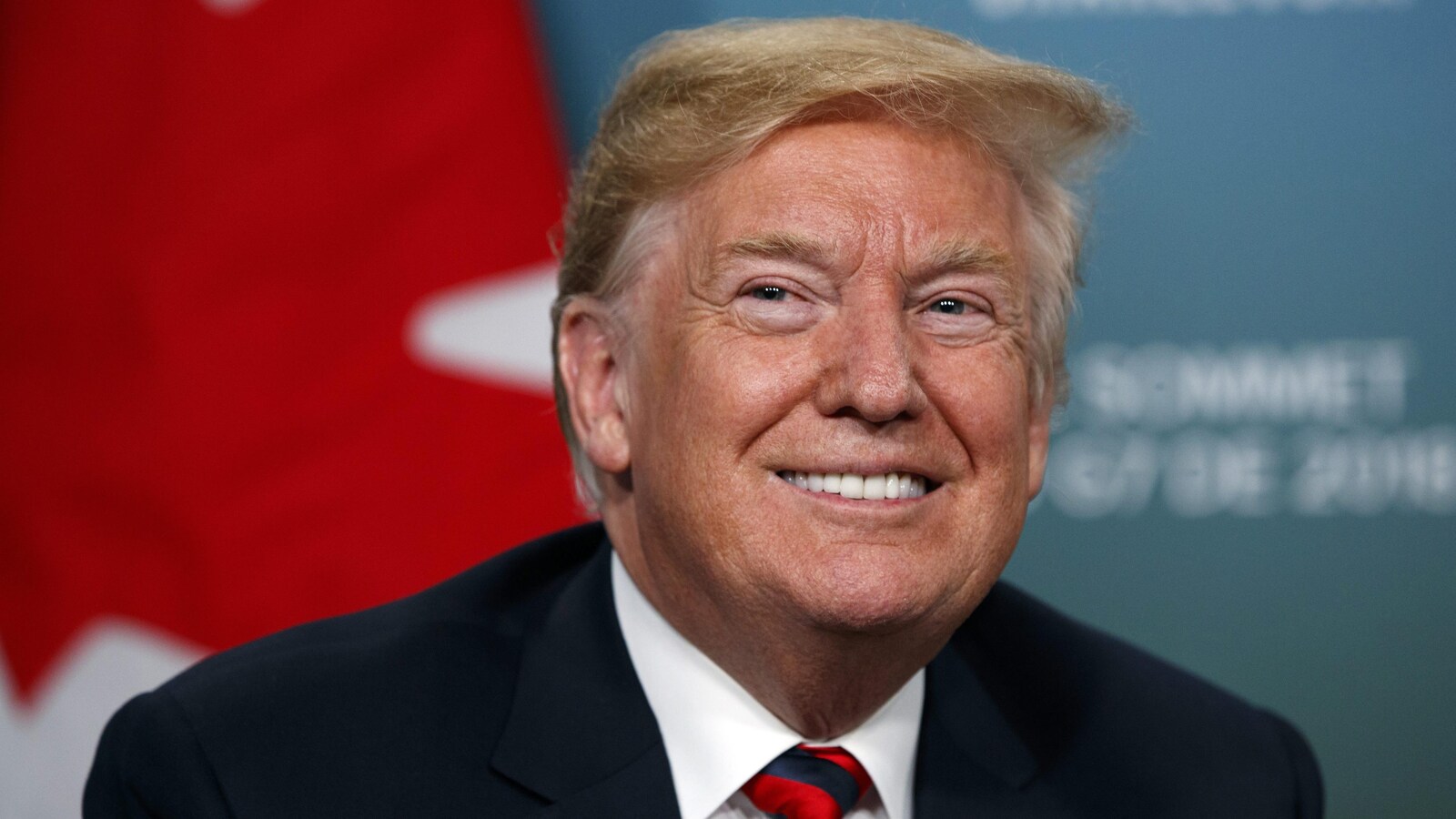 Donald Trump devant un drapeau du Canada.