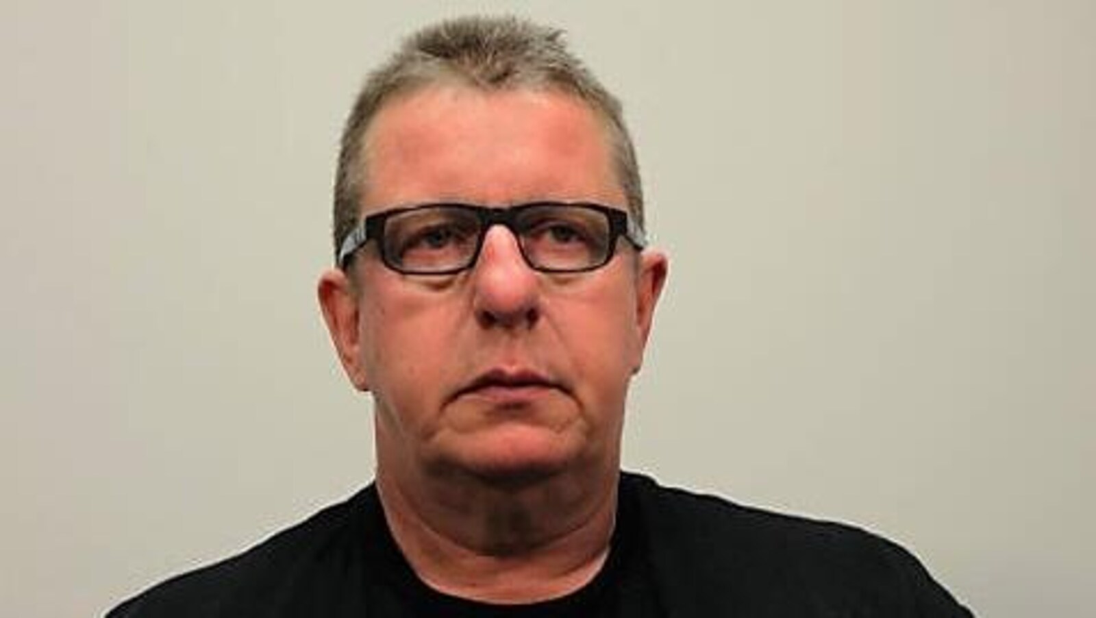 Photo de l'accusé, Donatien Beaulieu. Il porte un chandail noir et des lunettes. Il a les cheveux grisonnants coupés courts.