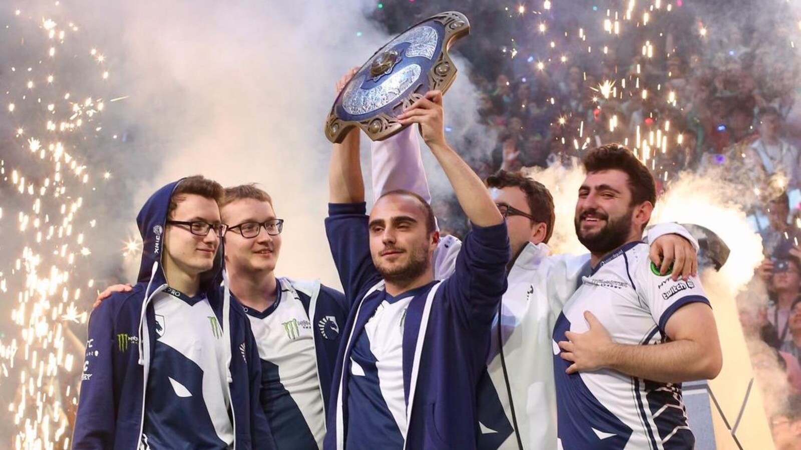 Cinq hommes soulèvent un trophée qui ressemble à un bouclier.