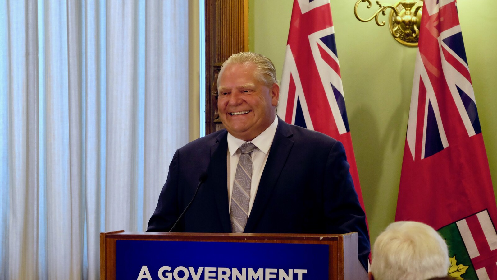 Photo de Doug Ford au podium portant un complet bleu