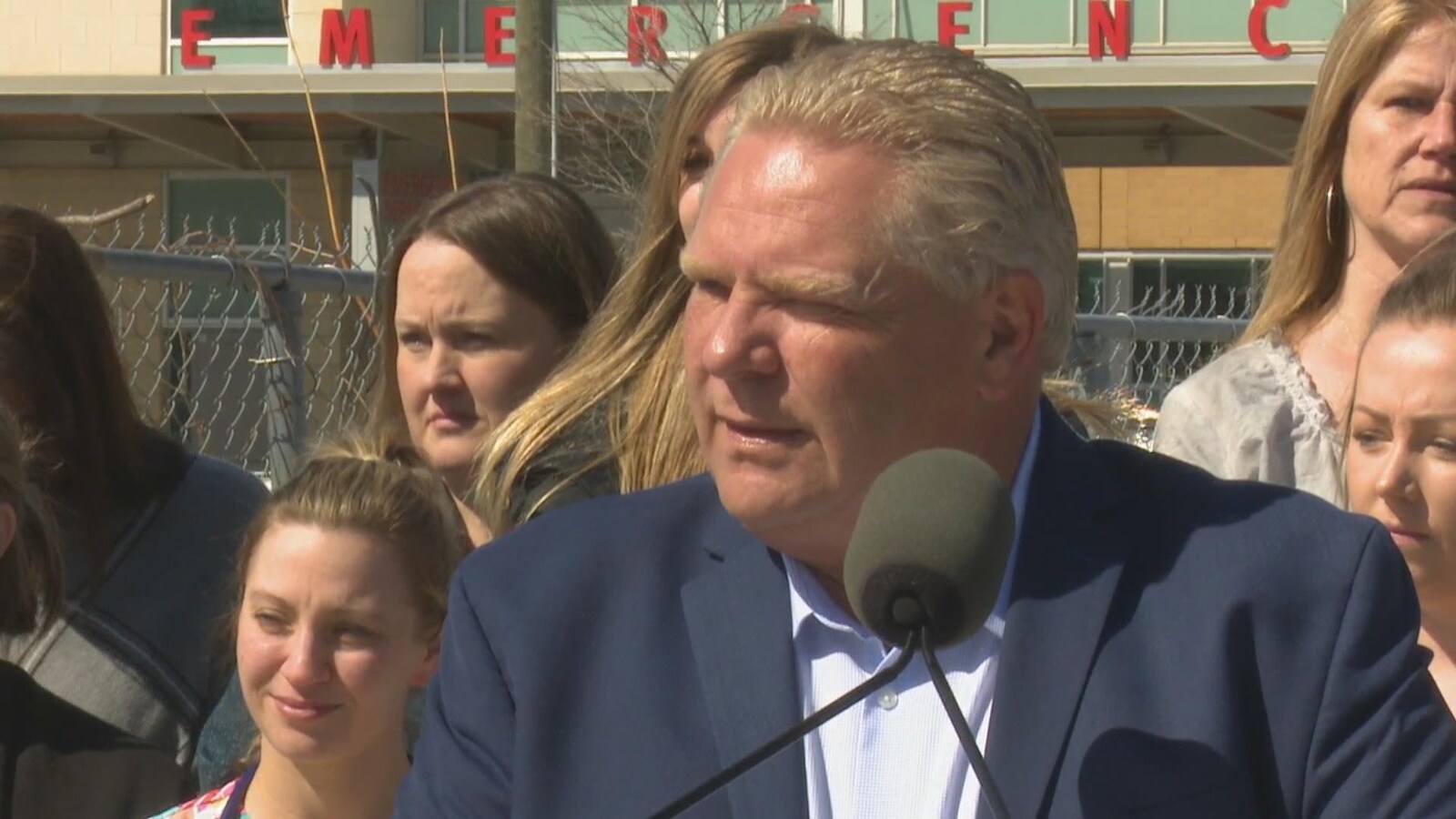 Portrait de Doug Ford derrière un micro.