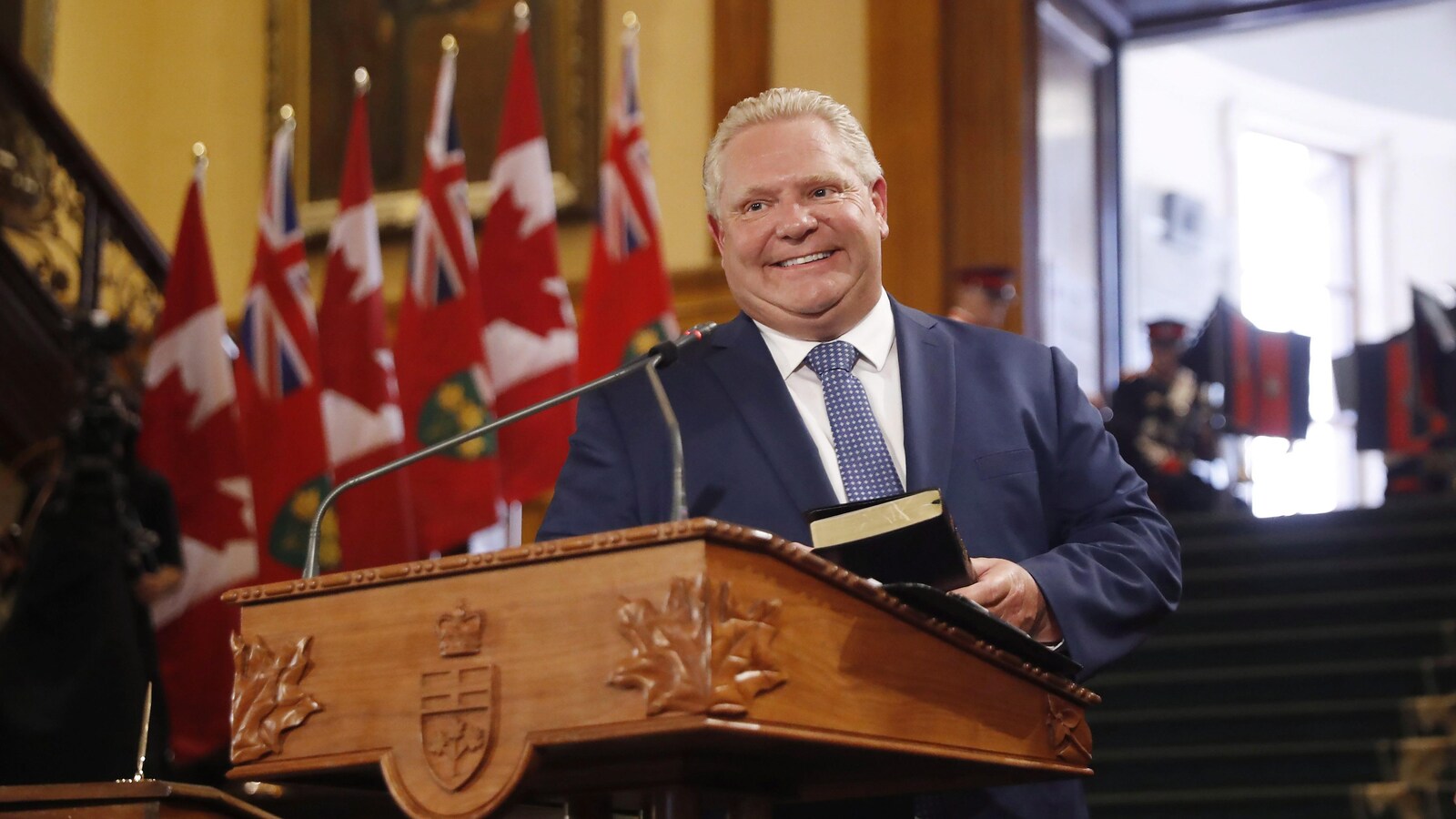 Doug Ford tient une main sur la bible.