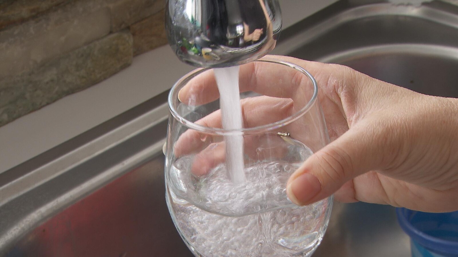 De l'eau coule du robinet dans un verre