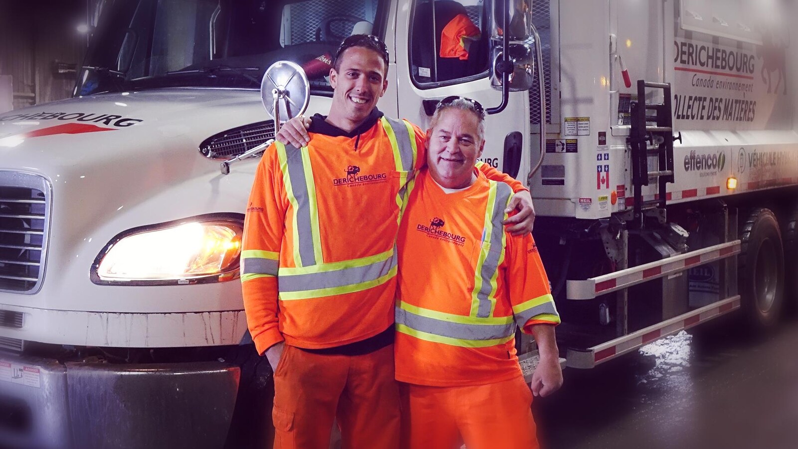 Des hommes vêtus d'orage posent côte-à-côte devant un camion.