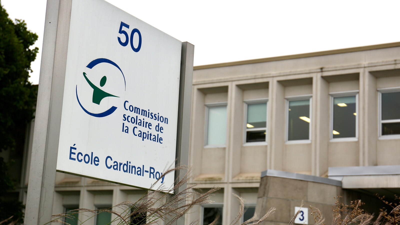 Vue de l'extérieur de l'école secondaire Cardinal-Roy à Québec avec une affiche de la Commission scolaire de la Capitale