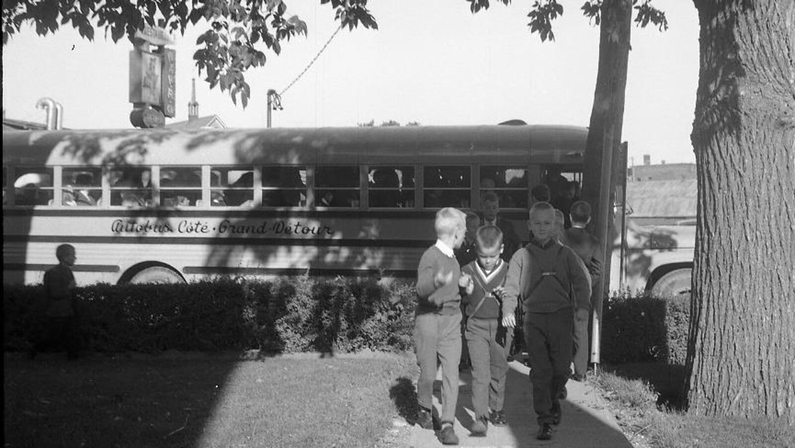 Garçons qui débarquent de l'autobus scolaire.