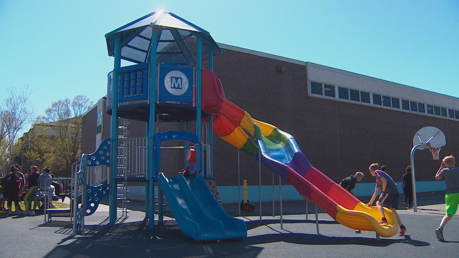 Enfants sur une glissoire dans la cour d'une école.