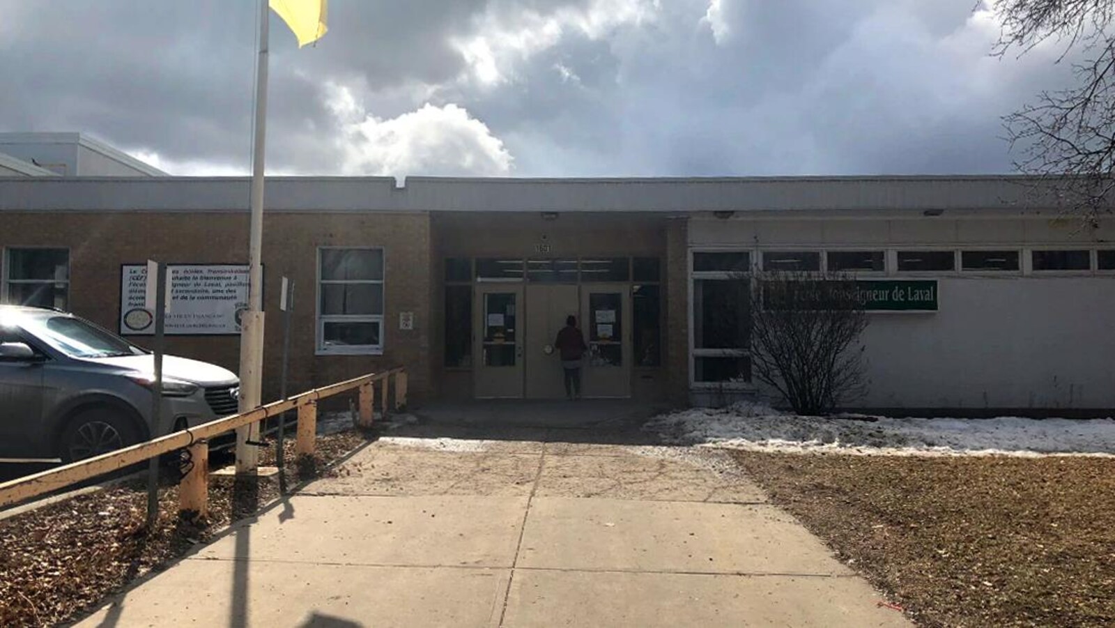 Le devant d'une école avec le drapeau fransaskois jaune et vert.