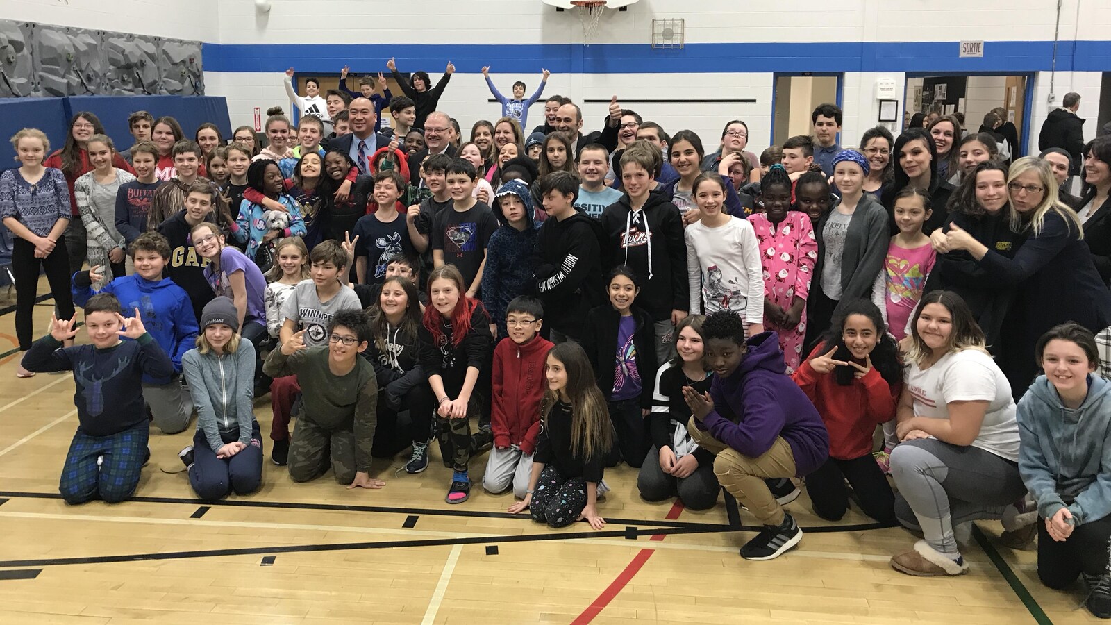 Les élèves de l'école posent avec le ministre Kelvin Goertzen et Bernard Lesage dans le gymnase.