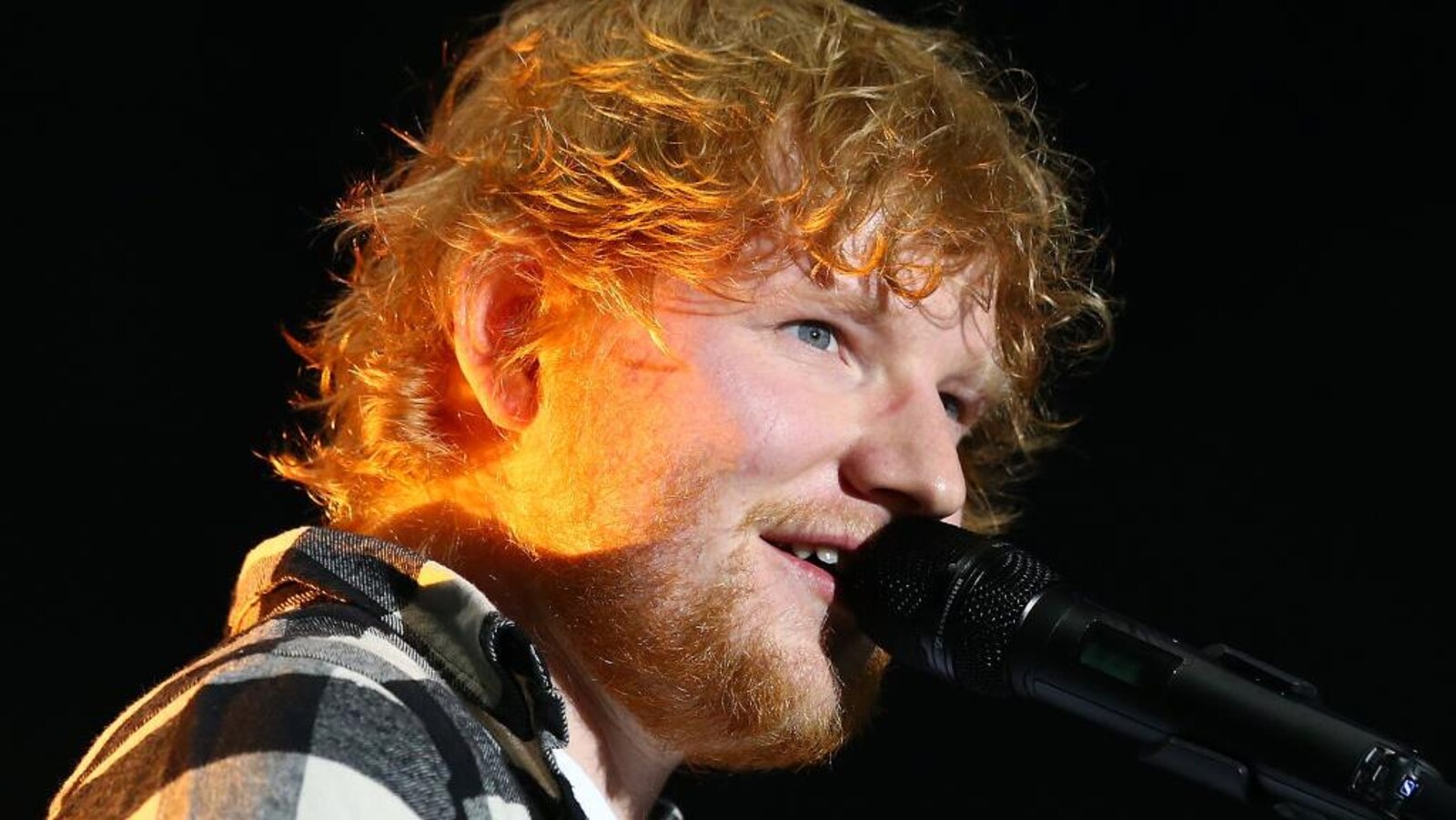 L'artiste britannique Ed Sheeran chante au micro.