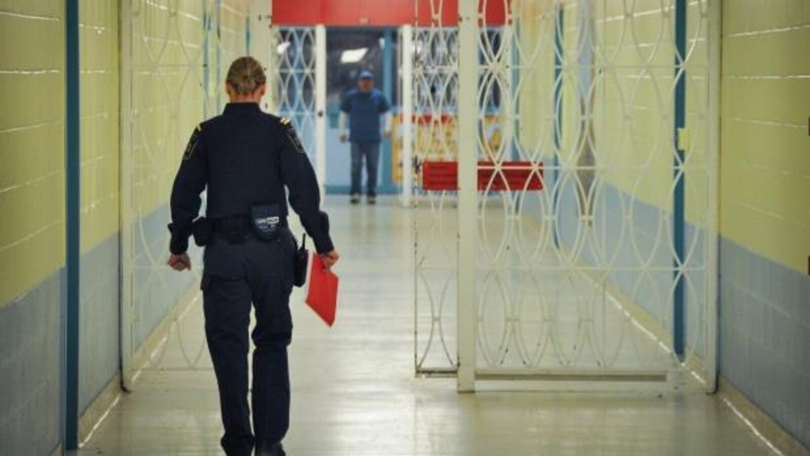Vue sur une agente de services correctionnels qui marche dans un couloir