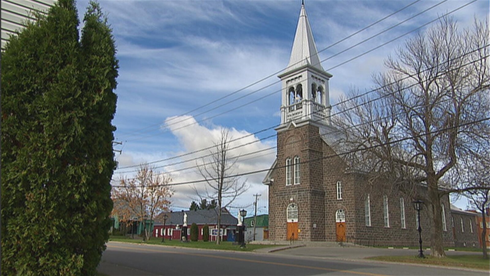 Un bâtiment religieux en brique grise se trouve au coeur du village.