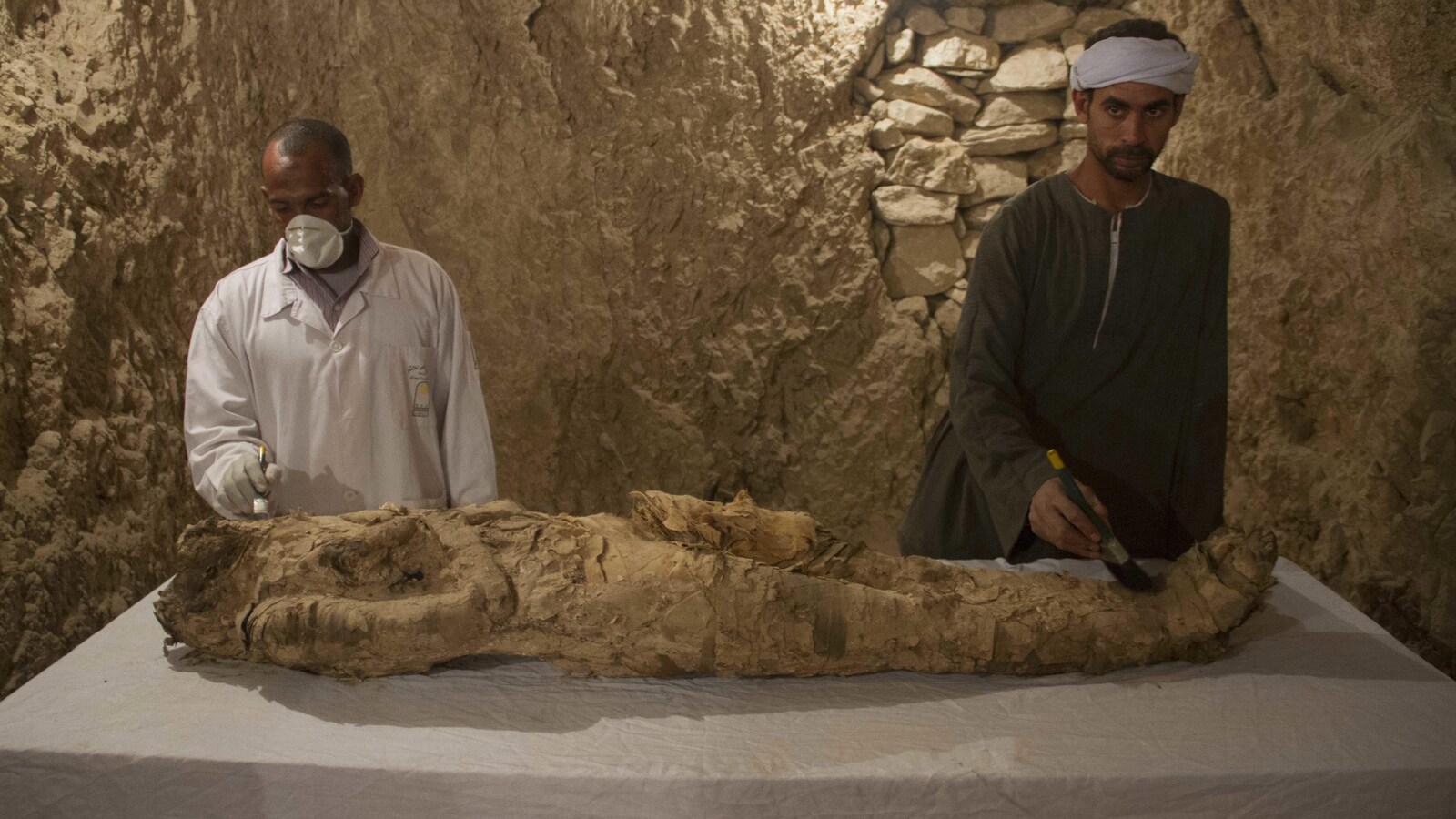 Des Égyptiens restaurent une momie dans une tombe nouvellement découverte à Louxor.