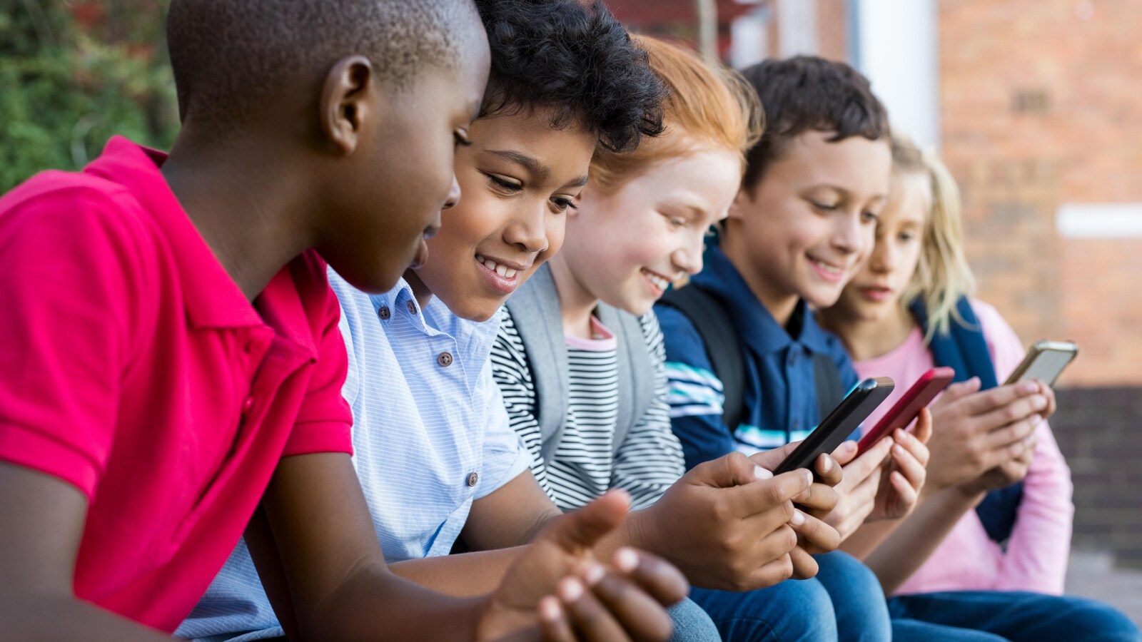Des enfants utilisant un téléphone intelligent.