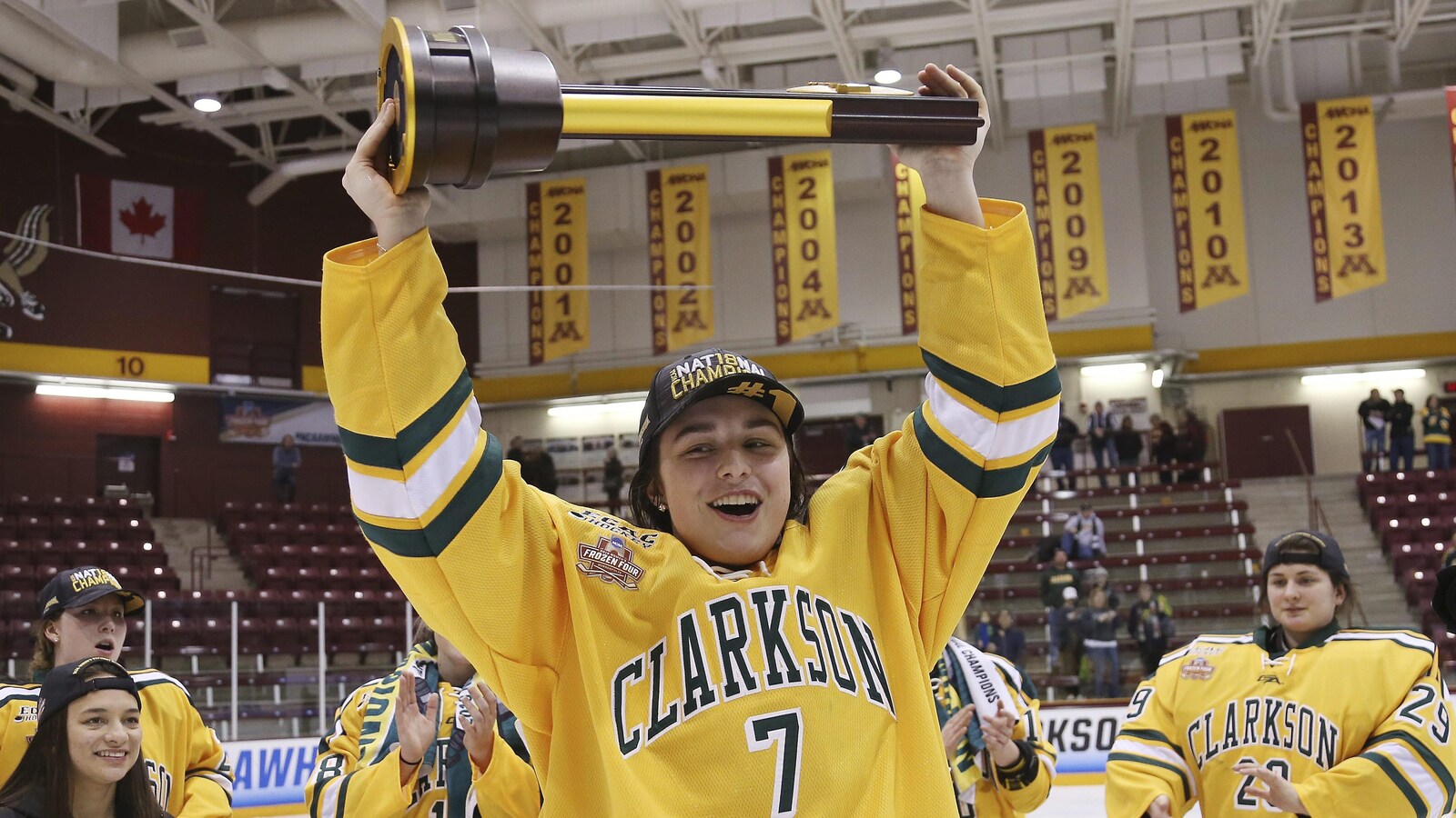 Auteure du but gagnant en prolongation, Elizabeth Giguère soulève le trophée remis à l'équipe championne du hockey universitaire américain (NCAA)