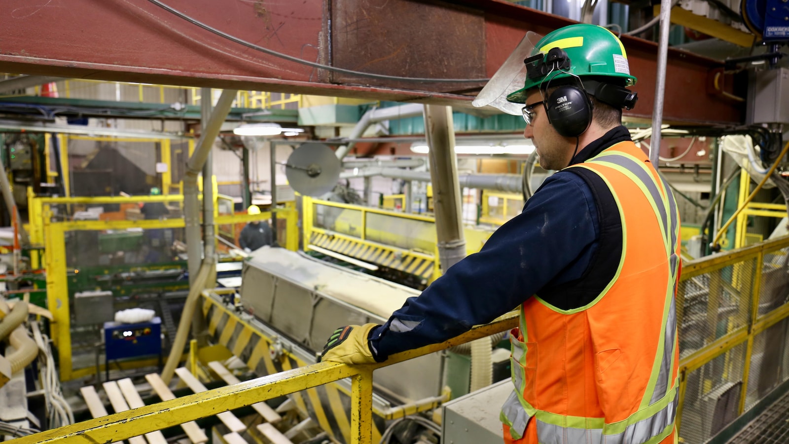 Un employé de Produits forestiers Résolu observe la machinerie.