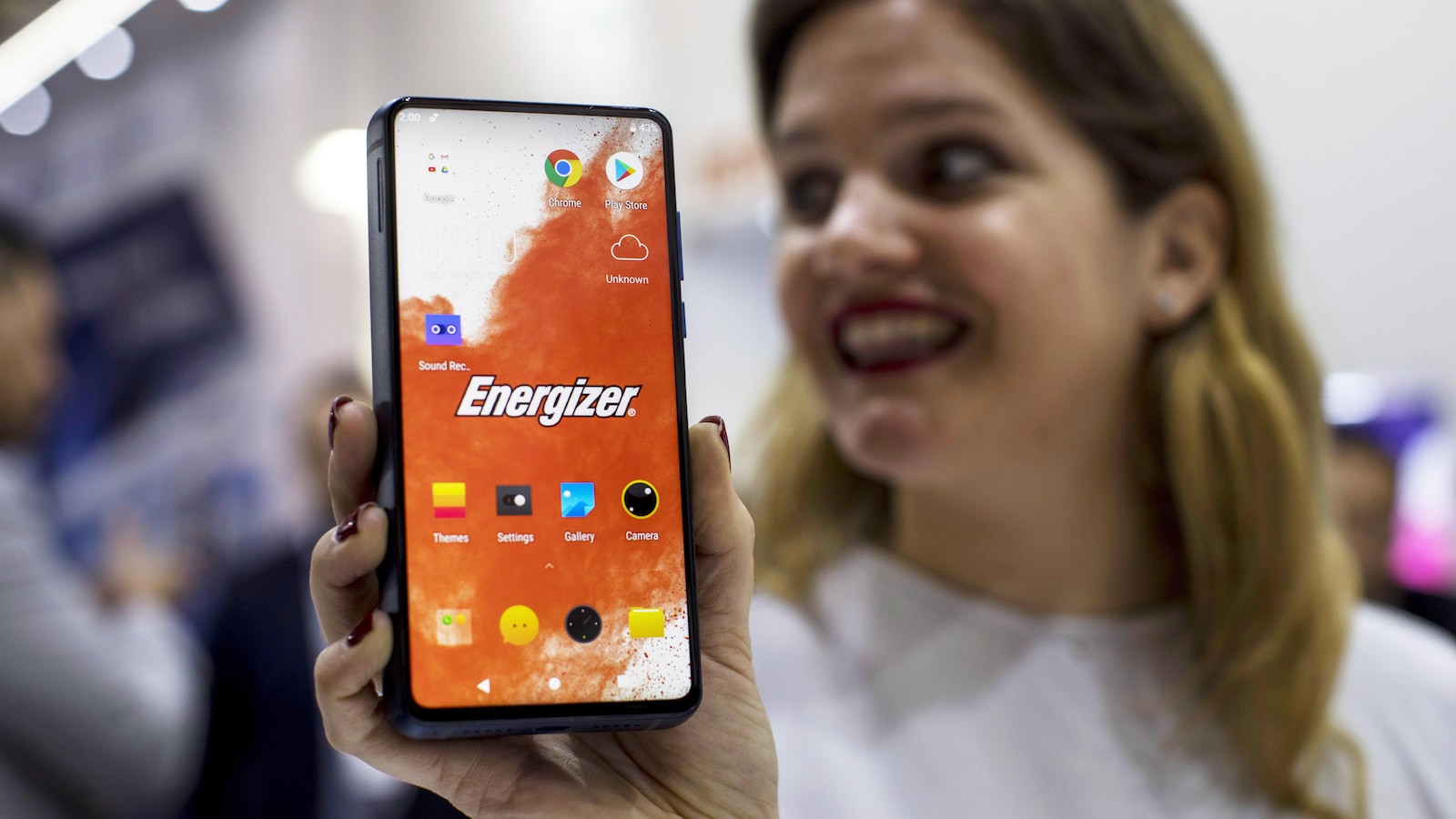 Une photo d'une femme qui tient un téléphone Power Max P18K dans sa main.