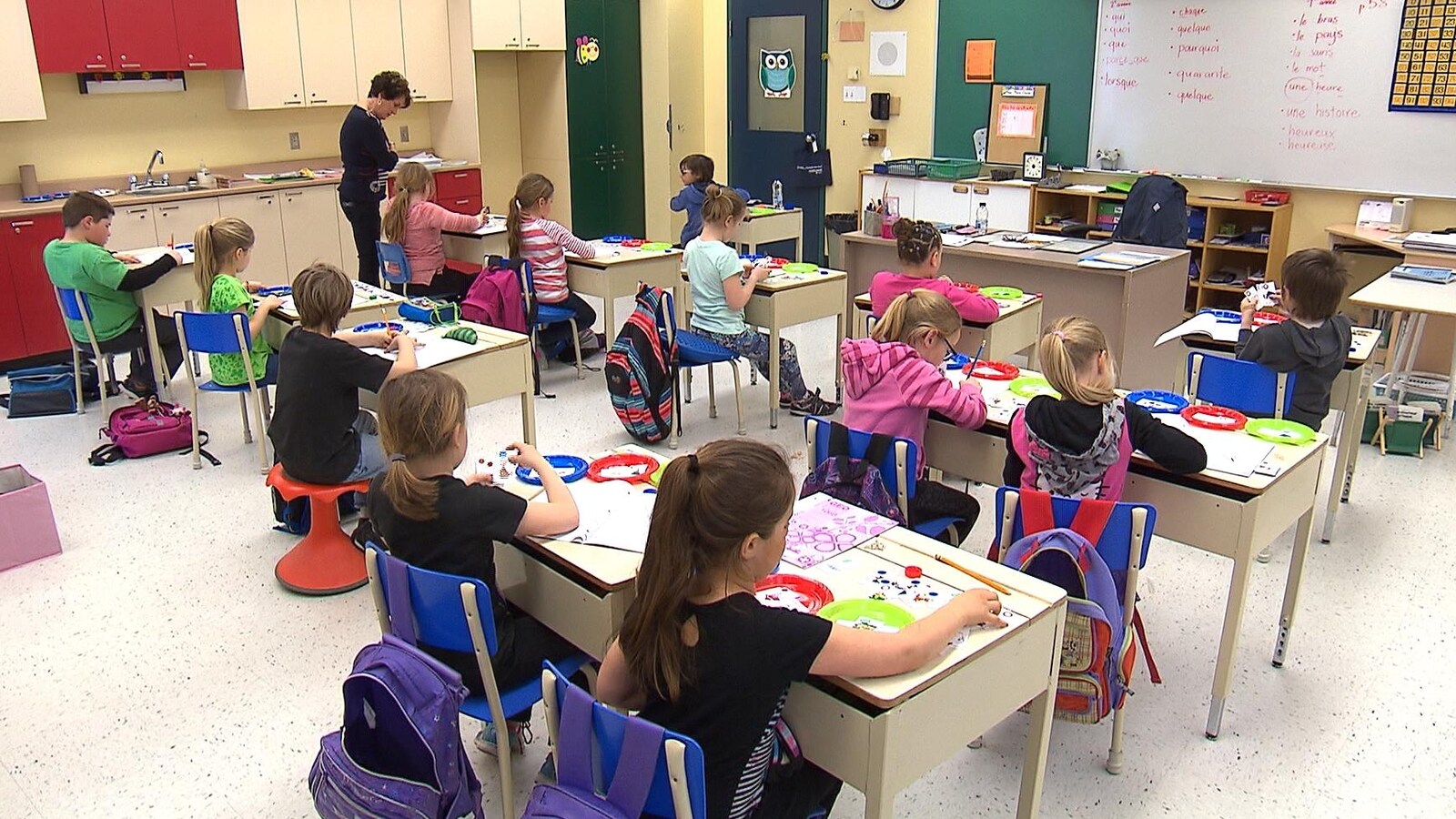 Une vingtaine de jeunes enfants assis dans une classe