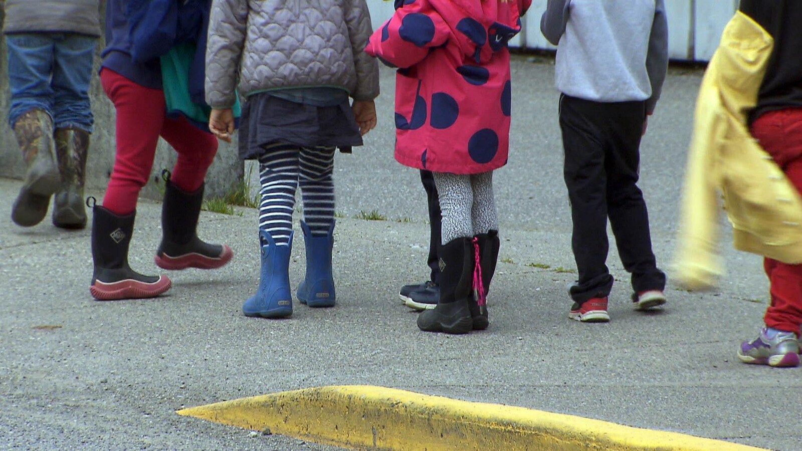 Des pieds d'enfants qui forment un rang.