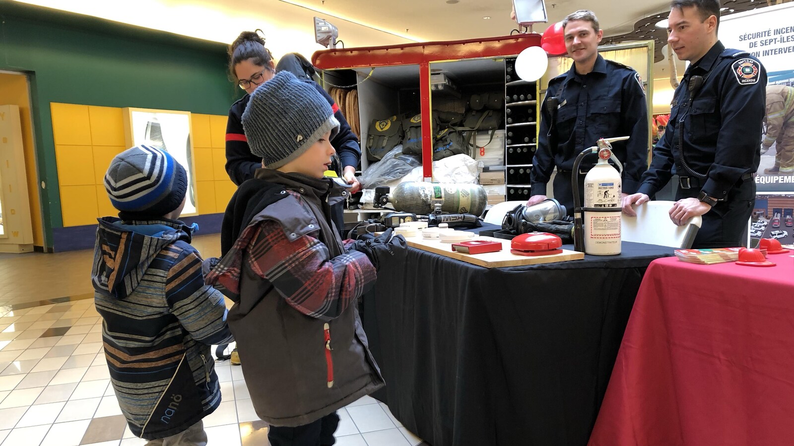 De très jeunes visiteurs s'intéressent au kiosque des pompiers de Sept-Îles
