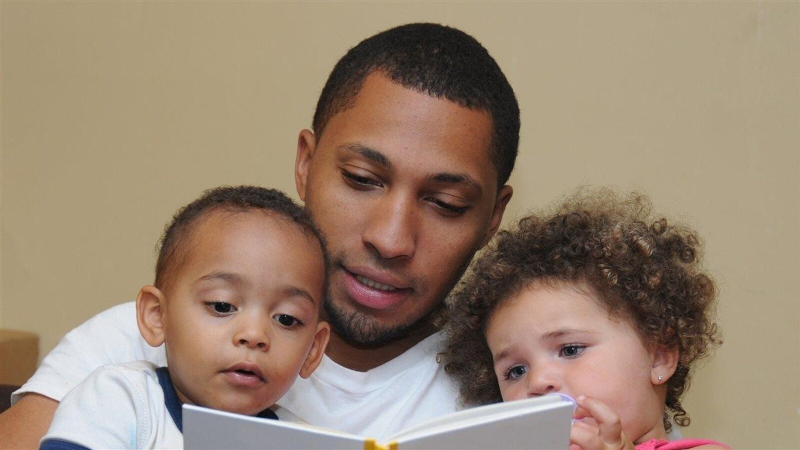 Un père lit avec ses enfants.