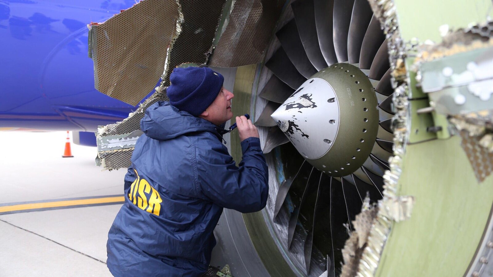 Un enquêteur du Bureau américain de la sécurité des transports examine le moteur endommagé de l'avion de Southwest Airlines qui a atterri d'urgence à Philadelphie le 17 avril 2018.