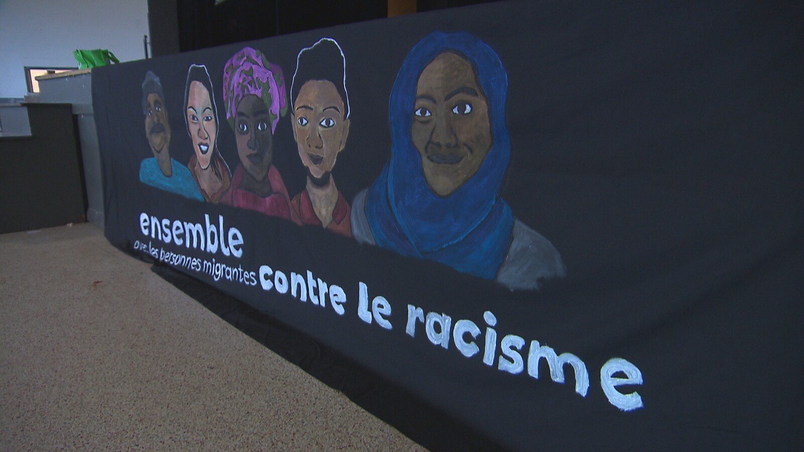 Une pancarte de Ensemble avec les personnes migrantes contre le racisme,