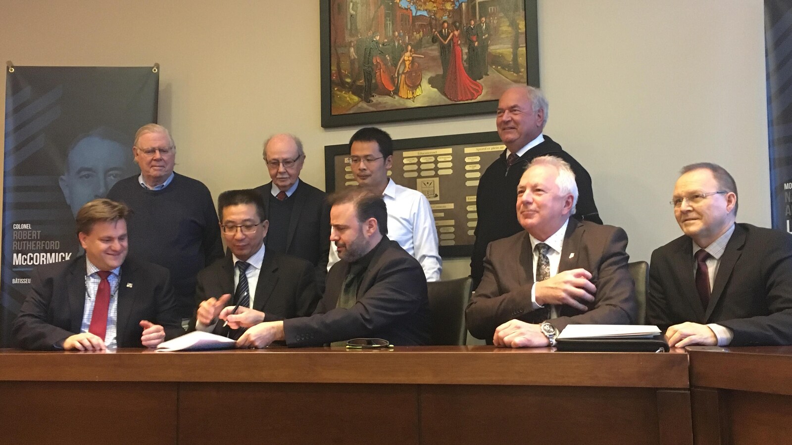 Les partenaires du projet signe l'entente. Ils sont assis autour d'un bureau.