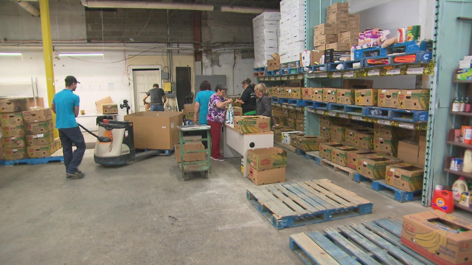 Des gens rangent des denrées dans des boîtes.