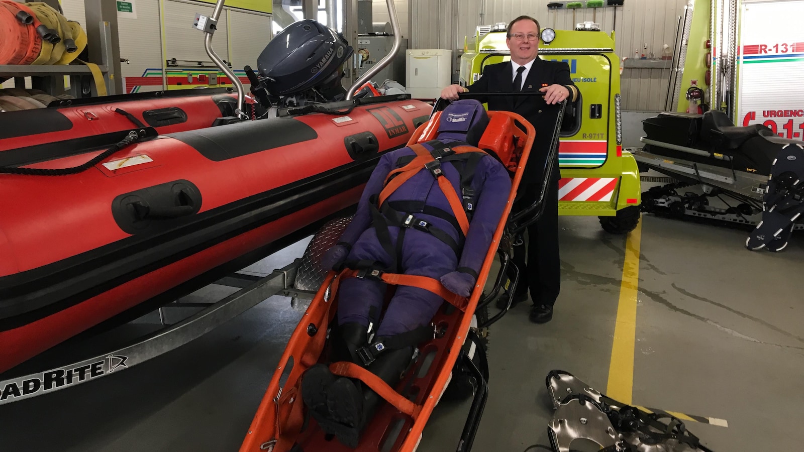 Un homme tient une civière près d'un nouveau canot pneumatique pour des interventions en zones isolées.