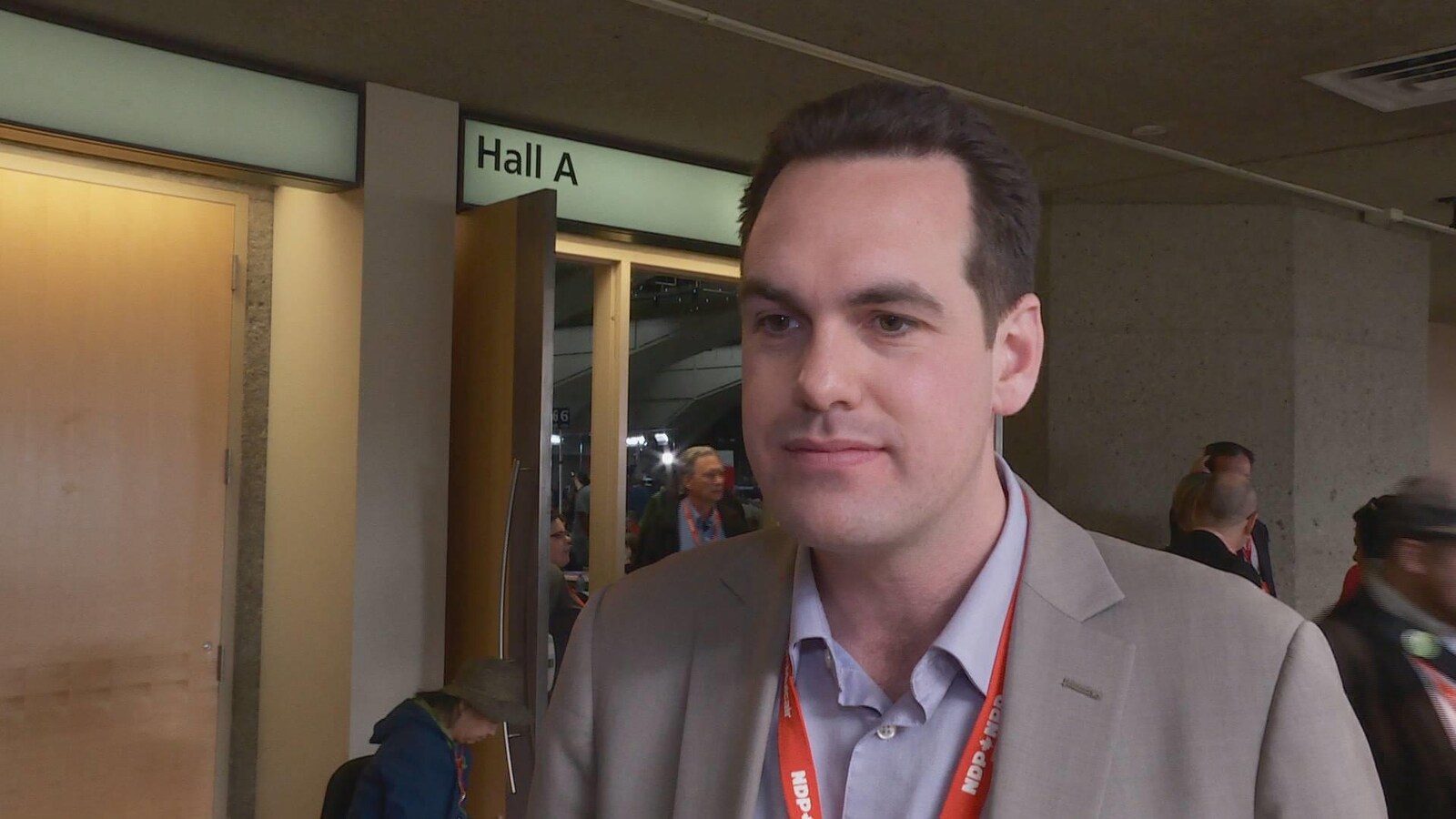 Le député Erin Weir interrogé à l'extérieur d'une salle de conférence