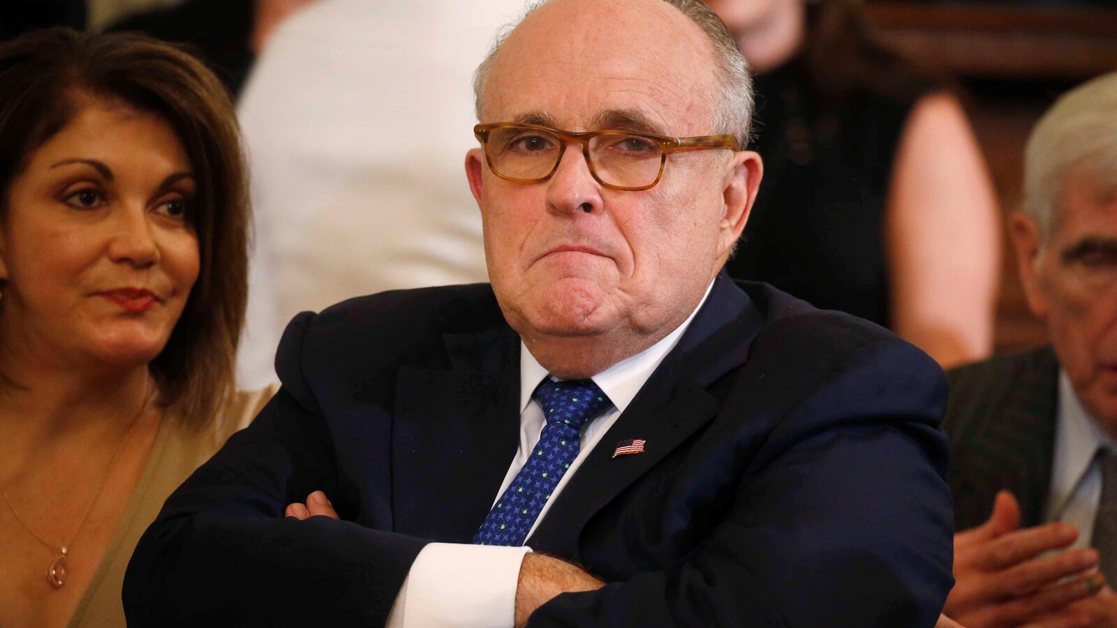 Rudy Giuliani assis, les bras croisés.