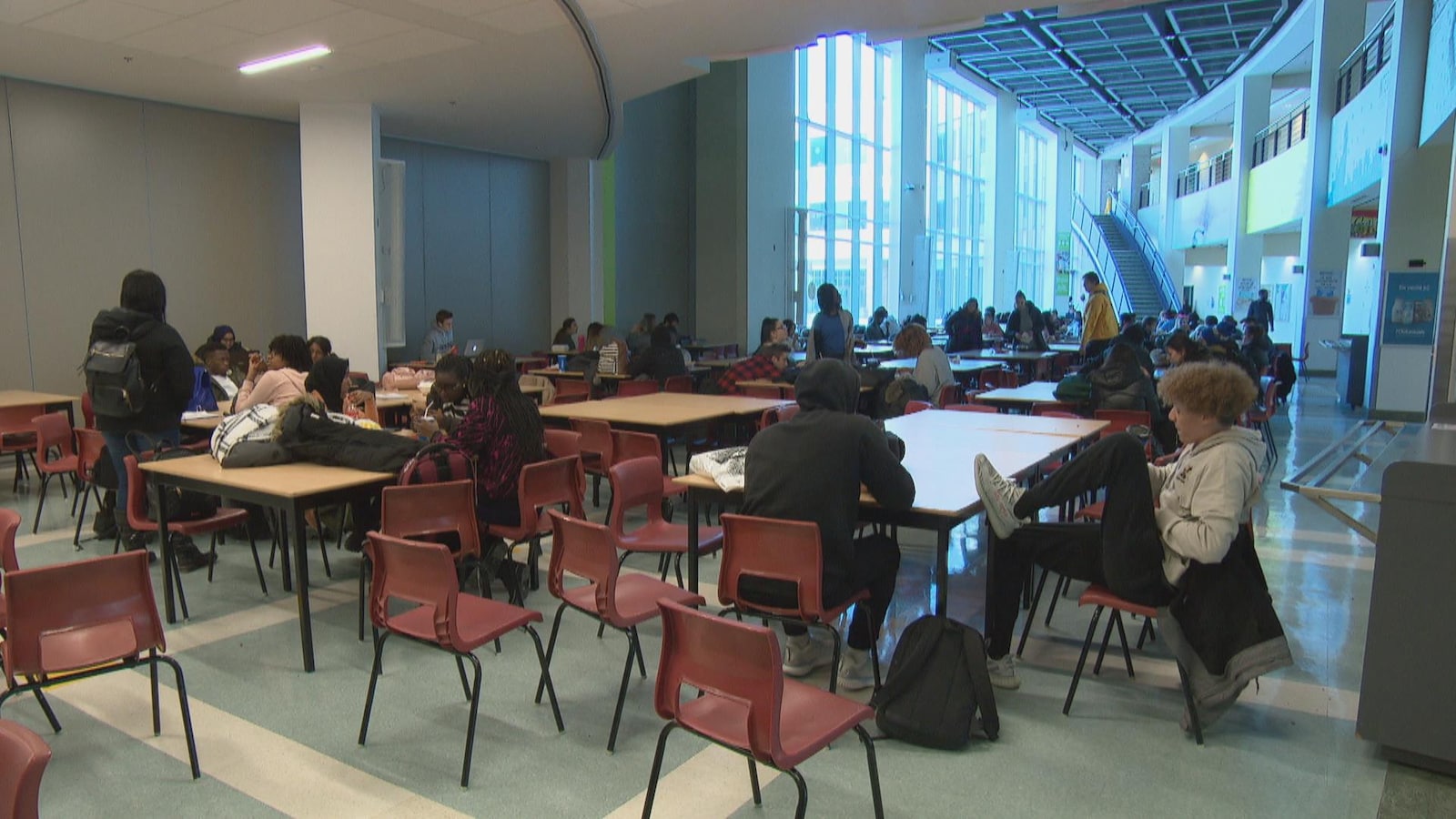 De jeunes adultes assis à des tables dans un agora