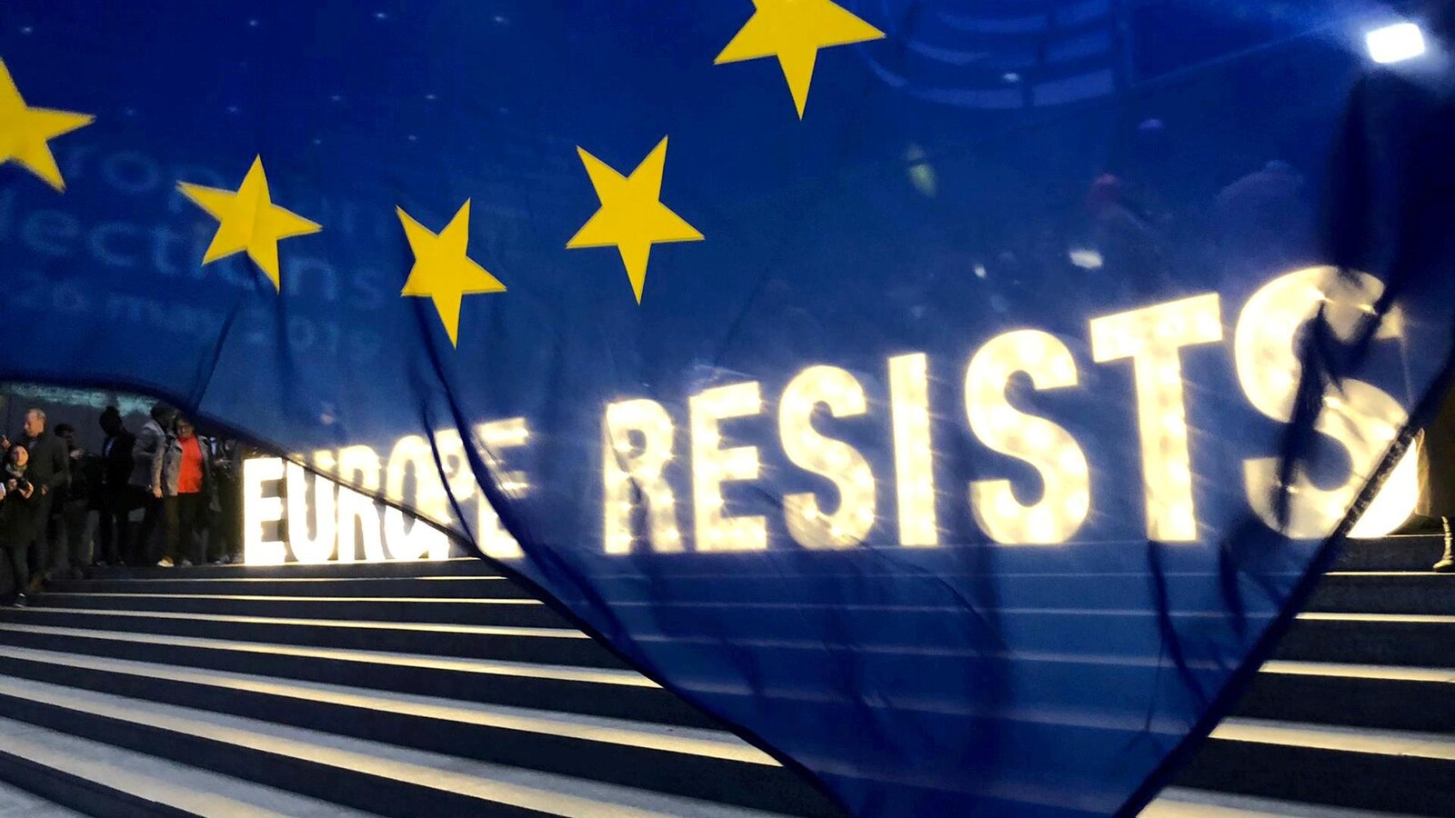 Un drapeau européen devant une inscription lumineuse « Europe resists », soit « l'Europe résiste »