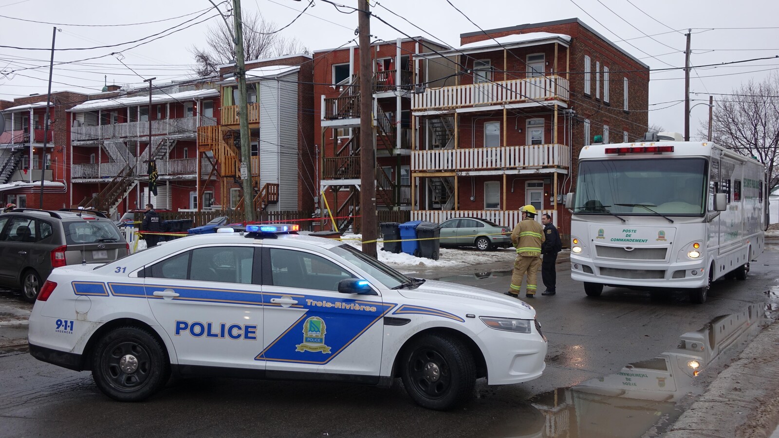 Une voiture et le poste de commandement de la police sur la rue Saint-Martin, à Trois-Rivières, près du lieu de l'explosion.
