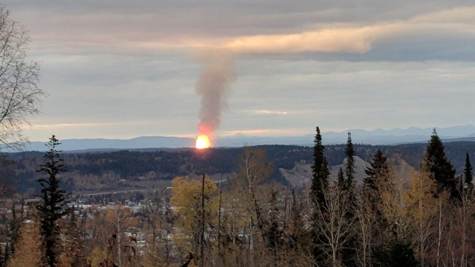Une boule de feu et un panache de fumée est visible à l'horizon.