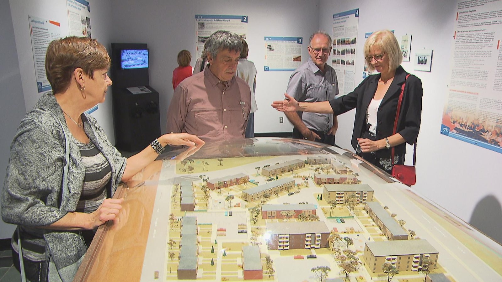 Des visiteurs observent la maquette d'un quartier