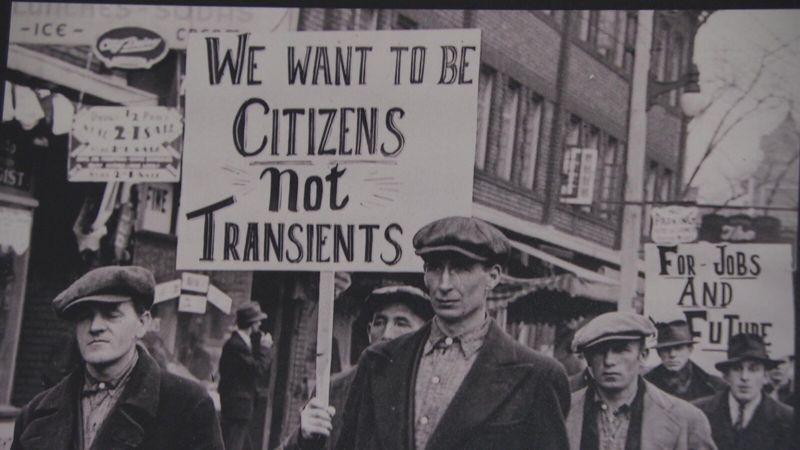 Des hommes brandissent des pancartes.