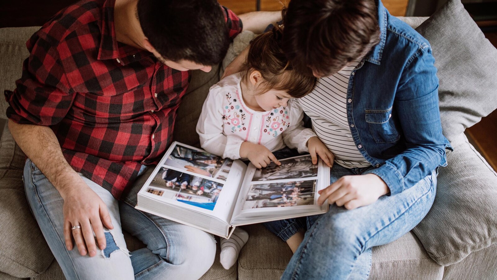 Une famille regarde un album de photos.