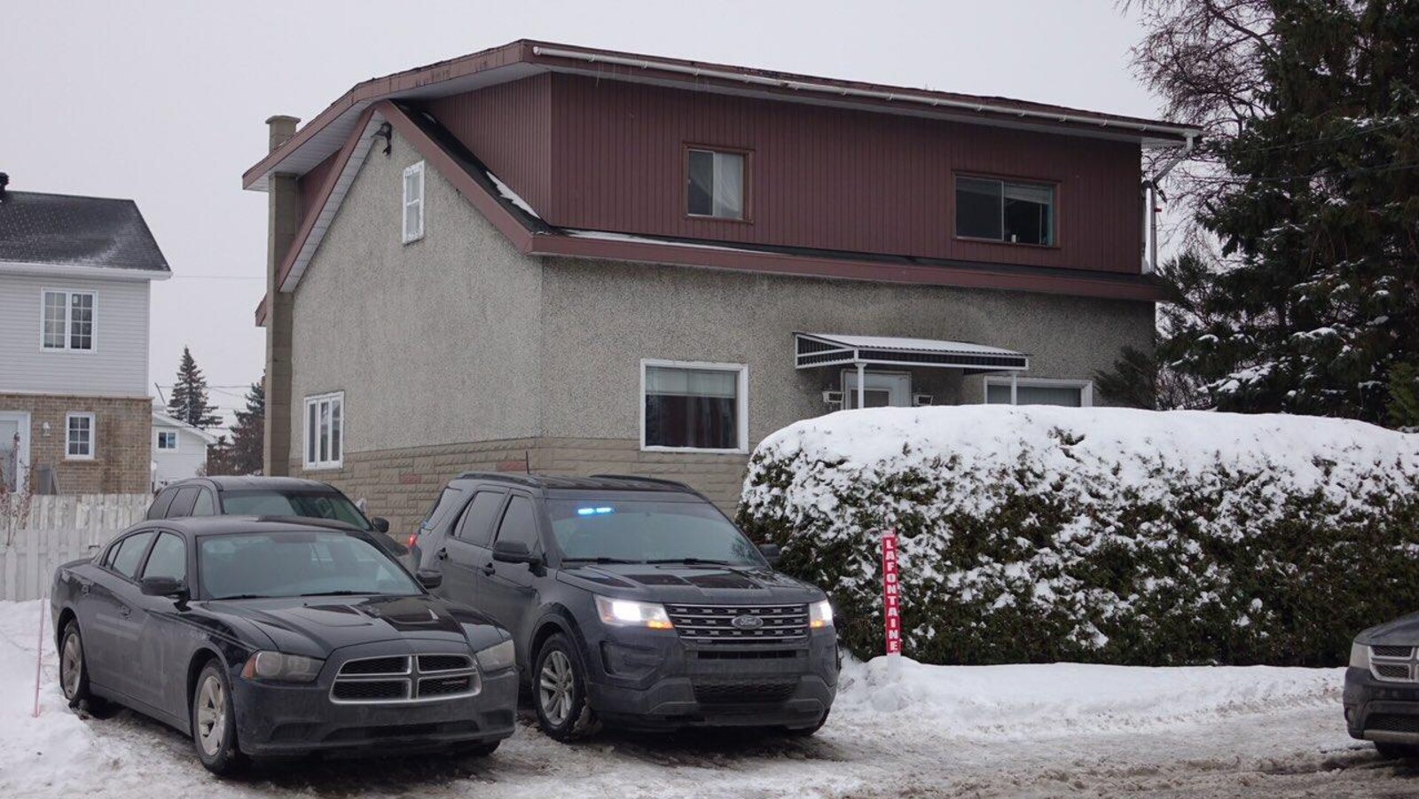 Deux voitures du FBI dans l'entrée d'une maison.