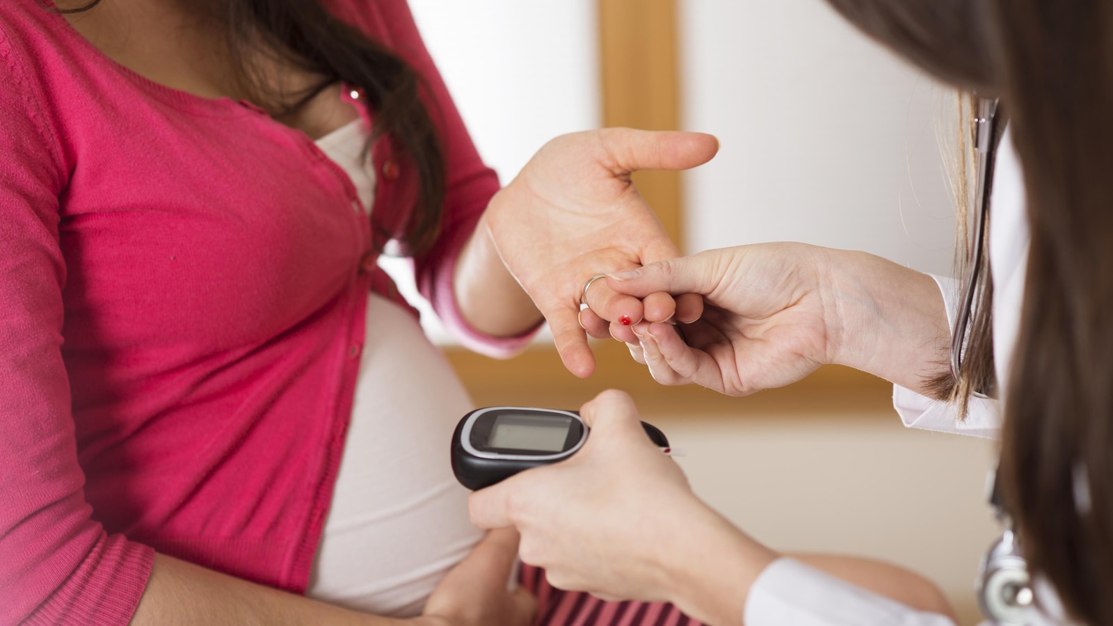 Un mÃ©decin teste le taux de sucre d'une femme enceinte.